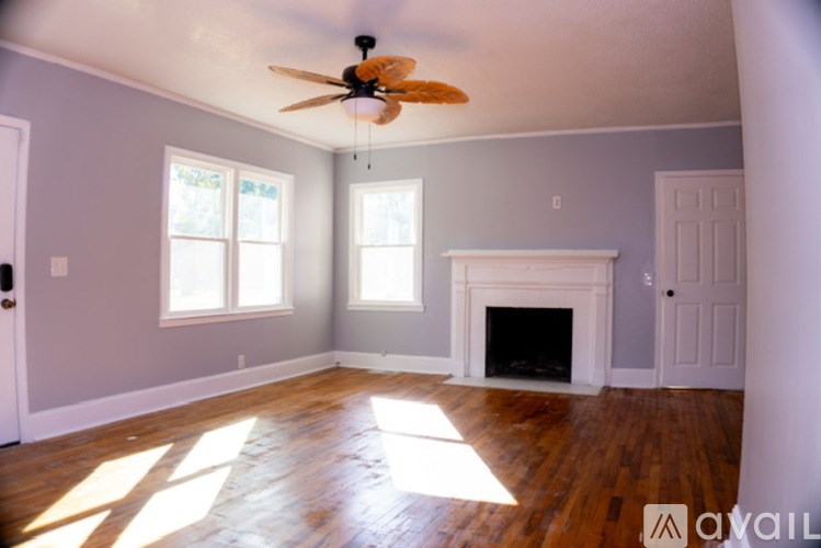 A room with a fireplace and a ceiling fan.