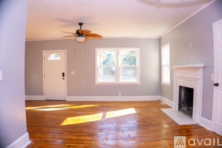 A room with a fireplace and a ceiling fan.