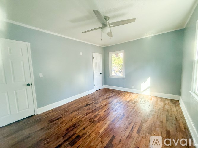 A room with wooden floors and a ceiling fan.