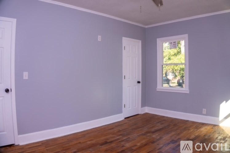 A room with wooden floors and two white doors.