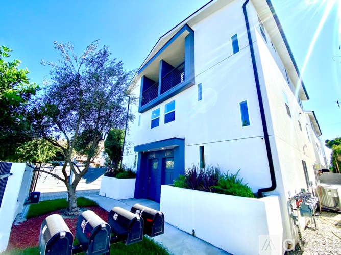 A white house with a blue door and mailbox.