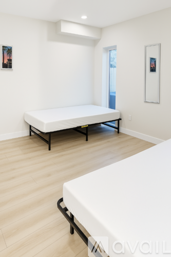 A bedroom with a white bed and a white mattress.