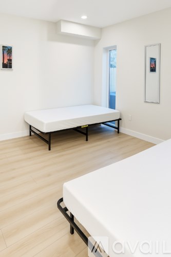 A bedroom with a white bed and a white mattress.