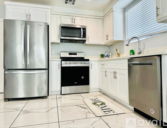 A kitchen with a stainless steel refrigerator, microwave, oven, and dishwasher.