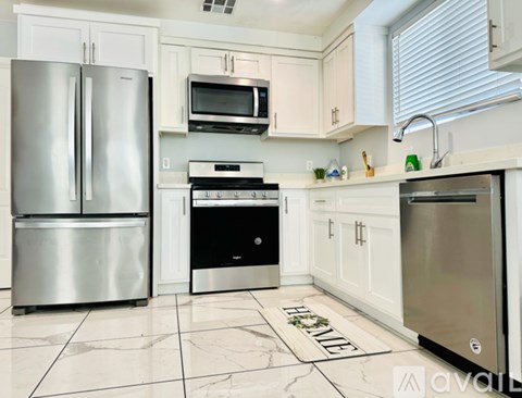 A kitchen with a stainless steel refrigerator, microwave, oven, and dishwasher.