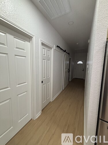 A hallway with white doors and wooden floors.