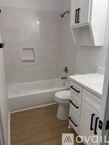 A white bathroom with a toilet, sink, and bathtub.
