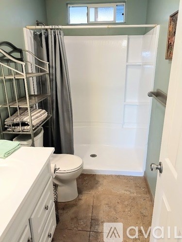 A bathroom with a toilet, sink, and shower.