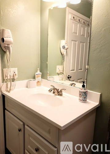 A bathroom with a white sink and a white door.