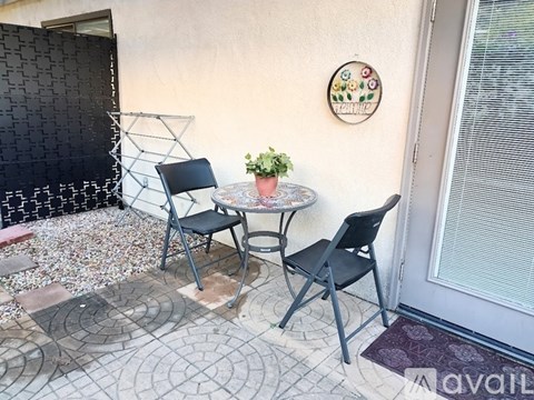 A small table with two chairs is set up on a patio.