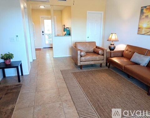A living room with a couch, chair, and lamp.