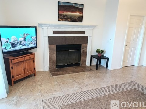 A living room with a fireplace and a television on a stand.