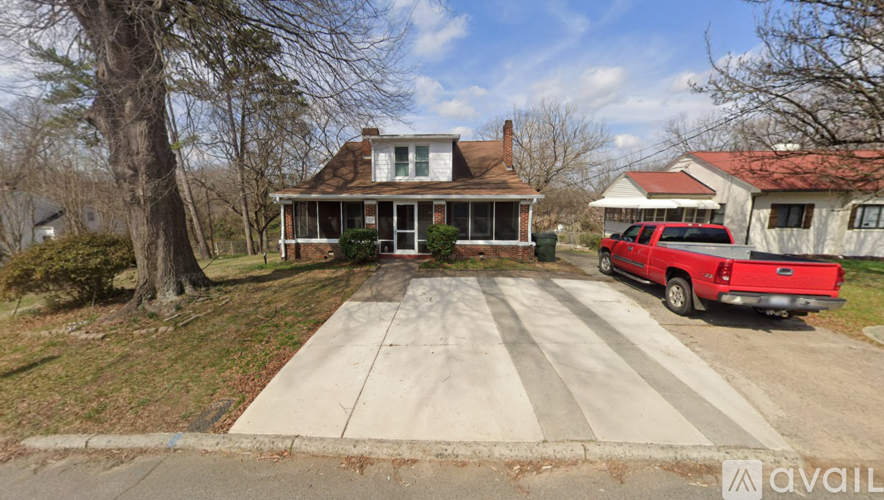 A house with a white front porch and a brick chimney.
