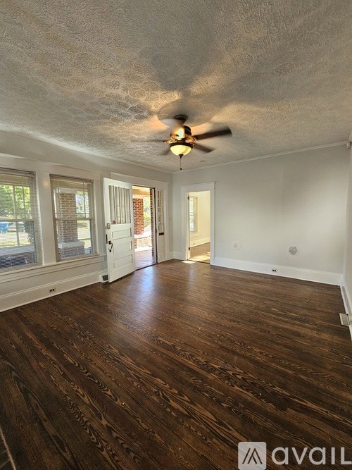 A room with wooden floors and a ceiling fan.