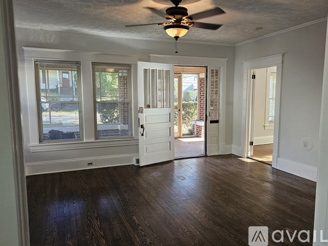 A room with a ceiling fan and wooden floors.