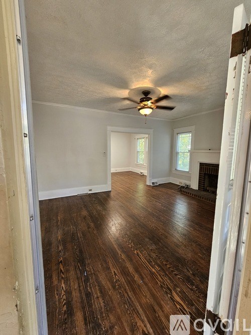 A room with wooden floors and a ceiling fan.