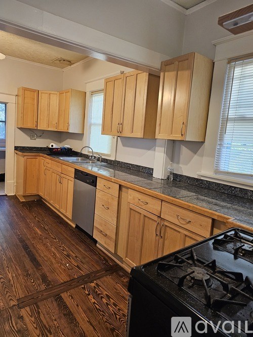 A kitchen with wooden cabinets and a black stove top.