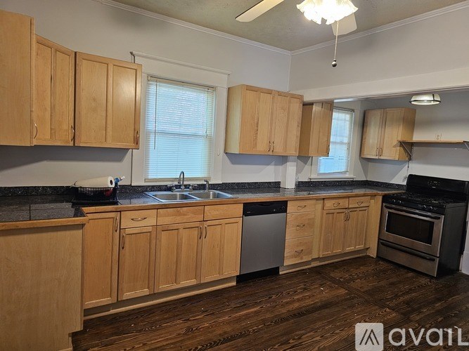A kitchen with wooden cabinets and a black countertop.