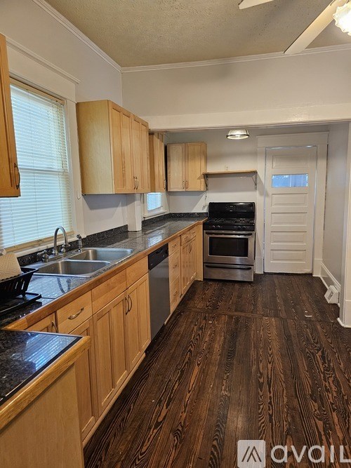 A kitchen with wooden cabinets and a black countertop.