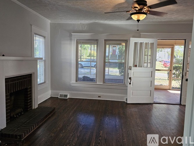 A room with a fireplace and a ceiling fan.