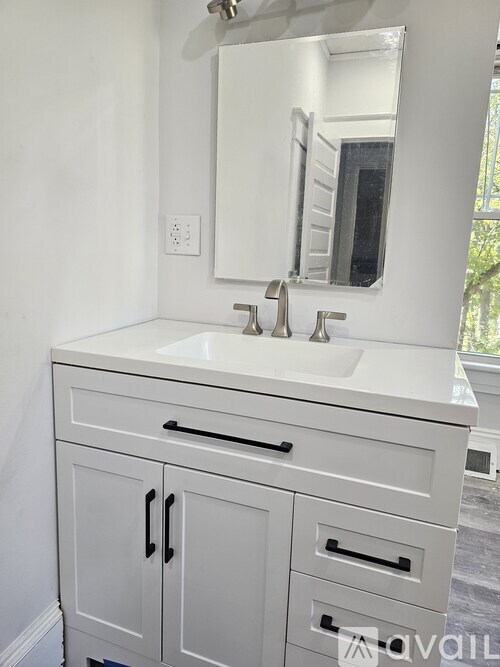 A white bathroom vanity with a mirror and a sink.