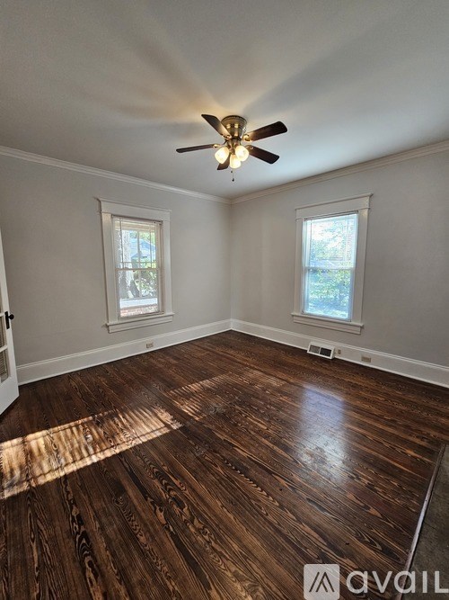 A room with wooden floors and a ceiling fan.