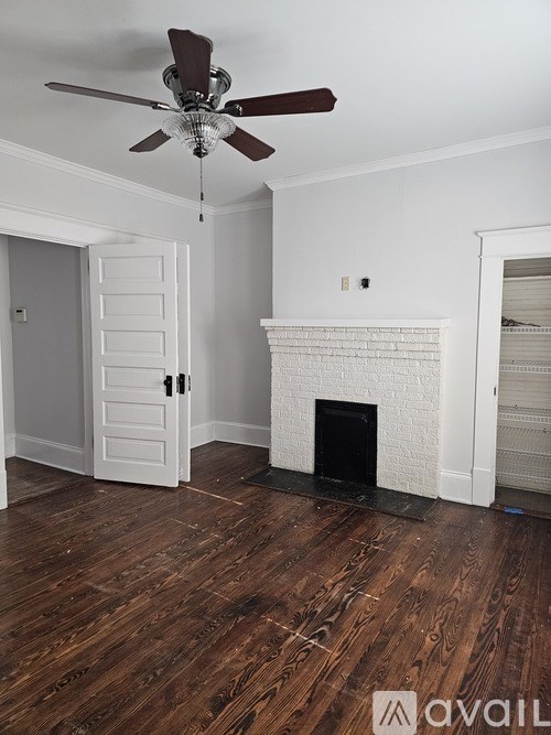 A room with a fireplace and a ceiling fan.