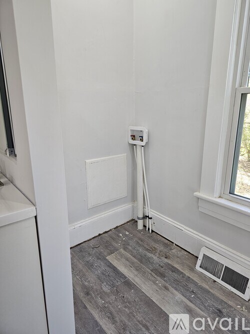 A bathroom with a window, a toilet, and a heater.