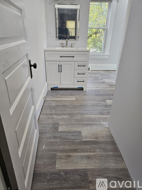 A bathroom with a white vanity and a window.