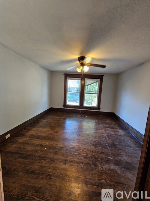A room with wooden flooring and a ceiling fan.