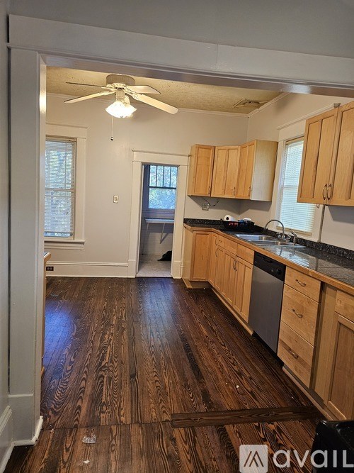 A kitchen with wooden floors and cabinets.