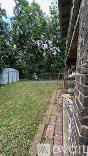 A backyard with a shed and a fence.