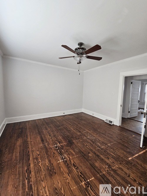 A room with wooden flooring and a ceiling fan.