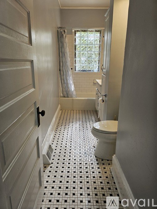 A bathroom with a toilet, sink and shower.