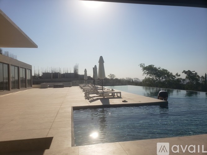 A sunny day at the poolside with a view of the city skyline.
