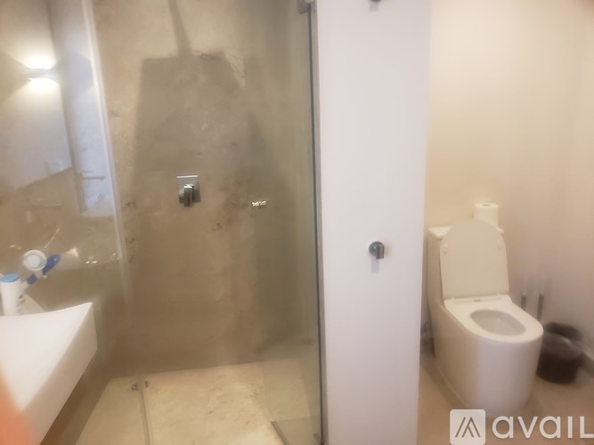 A bathroom with a toilet, sink, and shower.