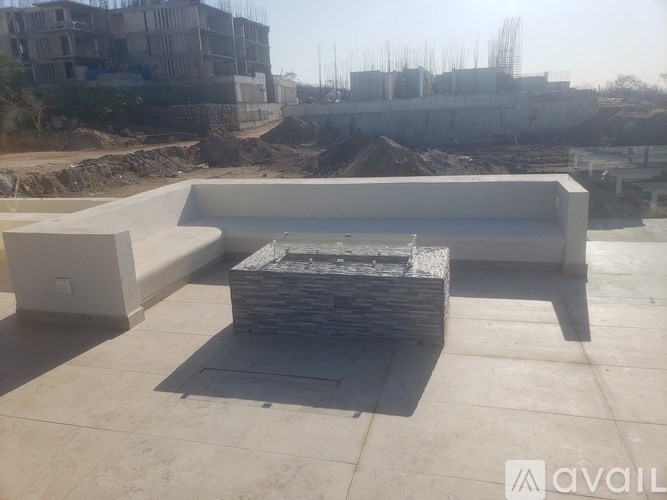 A construction site with a partially completed building in the background and a concrete patio in the foreground.