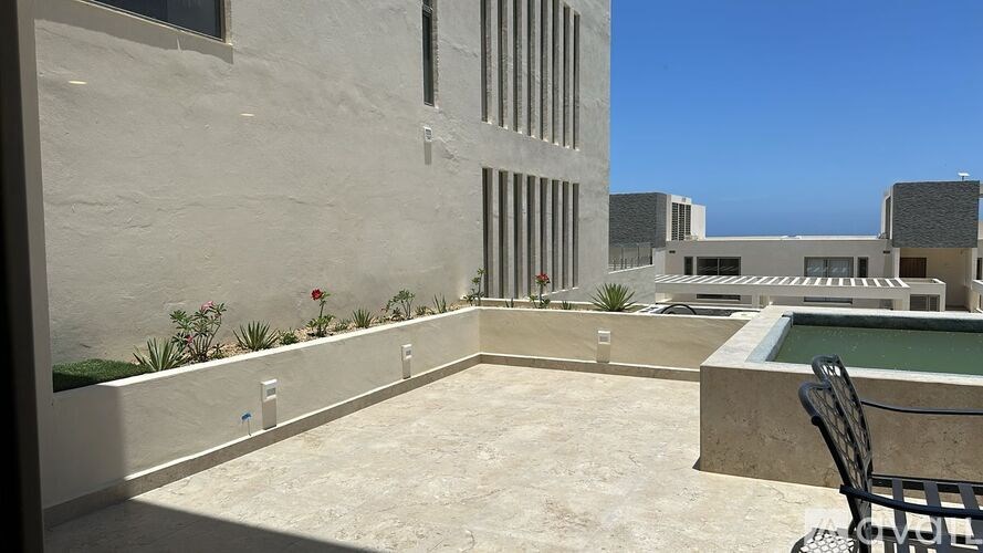 A patio with a table and chairs overlooks a courtyard.