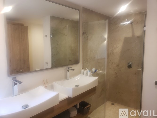 A bathroom with two sinks and a walk-in shower.