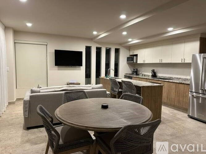 A modern kitchen and dining area with a table set for four.