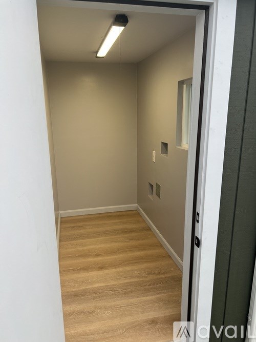 A hallway with a white door and a light on the wall.