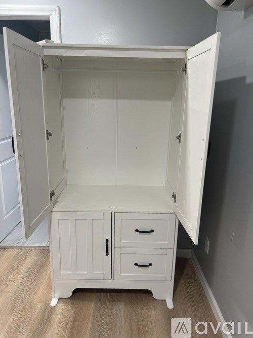 A white cabinet with two drawers is open.