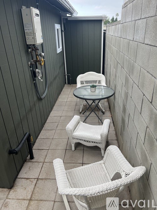 A patio with a table and chairs and a wall with a lock on it.