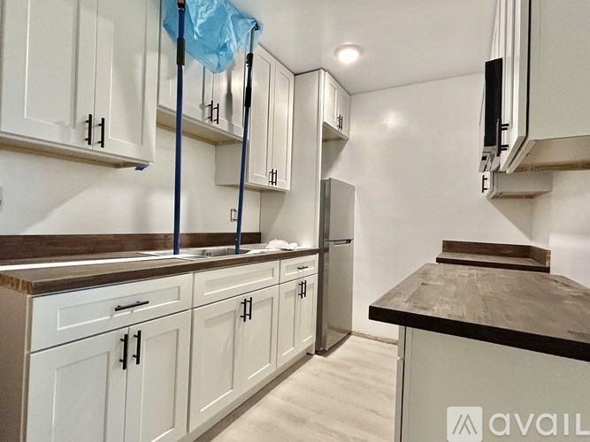 A kitchen with white cabinets and a black countertop is under construction.