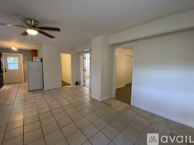 A spacious room with a ceiling fan and tiled flooring.