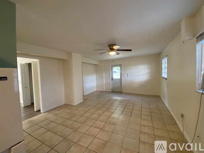 A spacious room with a ceiling fan and tiled flooring.