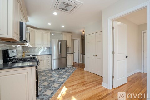 A kitchen with white cabinets and a black countertop.
