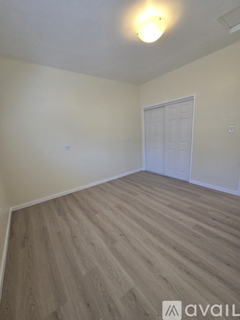 A room with wooden flooring and a white door.