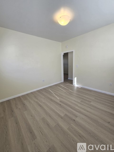 A room with wooden flooring and a white door.