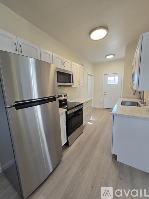 A modern kitchen with stainless steel appliances and white cabinets.